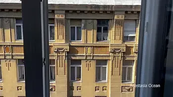 A woman undresses on a balcony in the city center. Public flashing.