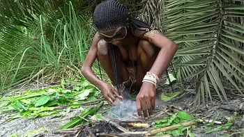 Hot African native woman cooking in the jungle