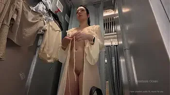 I try on clothes in fitting room with open curtain. People are passing and watching on me.