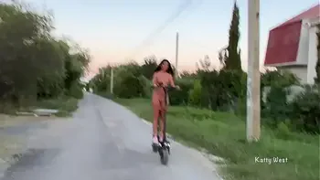 A naked girl rides a scooter through the streets and shocks passers-by naked on public