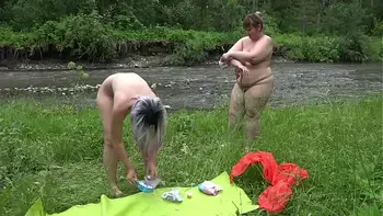Voyeur spying on mature lesbians with big butts outdoors. Chubby milfs wash near the river in nature. Amateur fetish and PAWG. Nudism and exhibitionism.